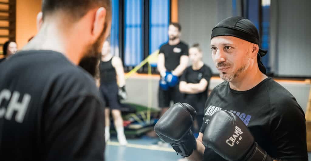 oach supervisant un combat au club de Krav Maga Mons